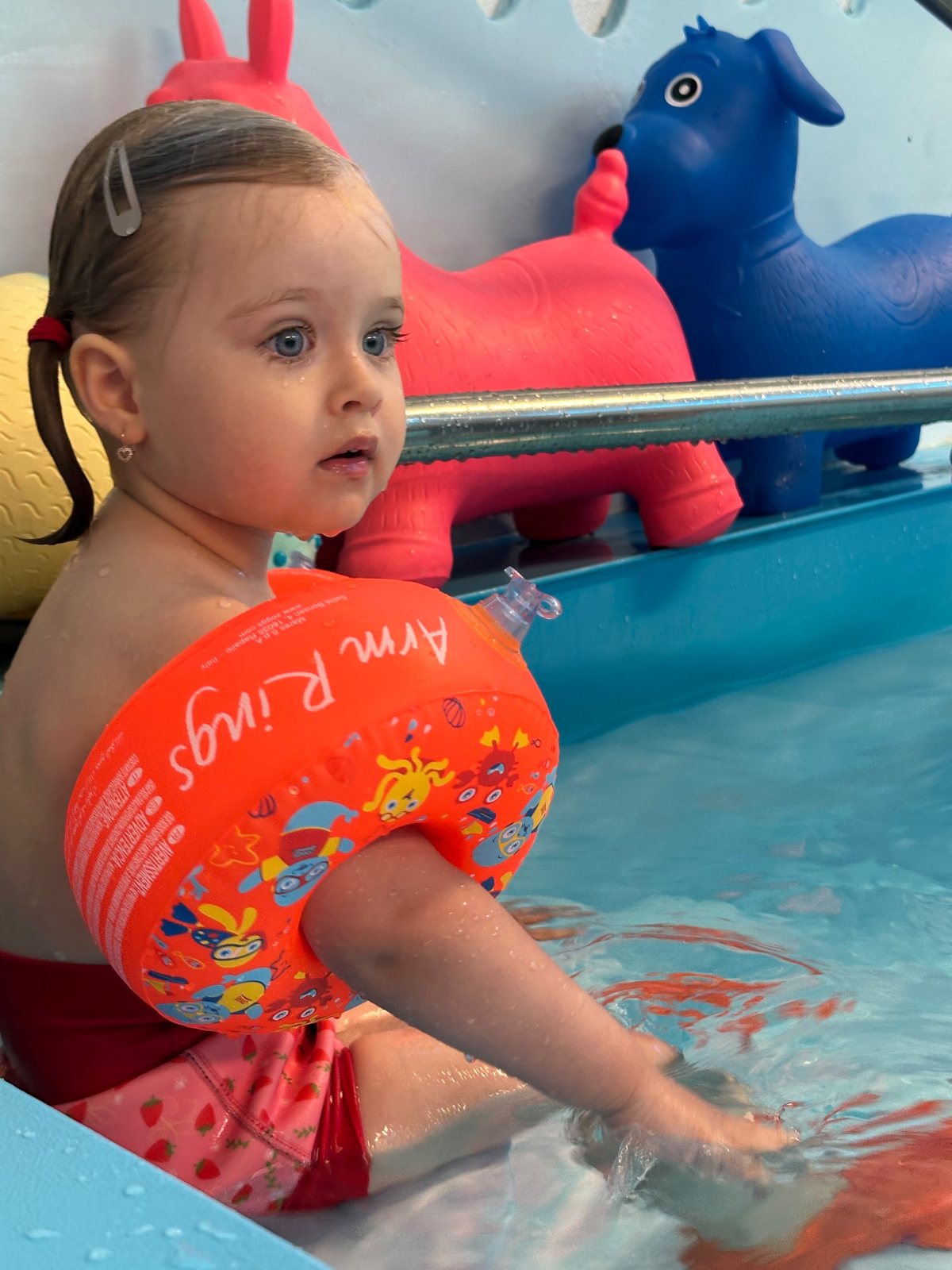 Dieťa s rukávnikmi pri bazéne